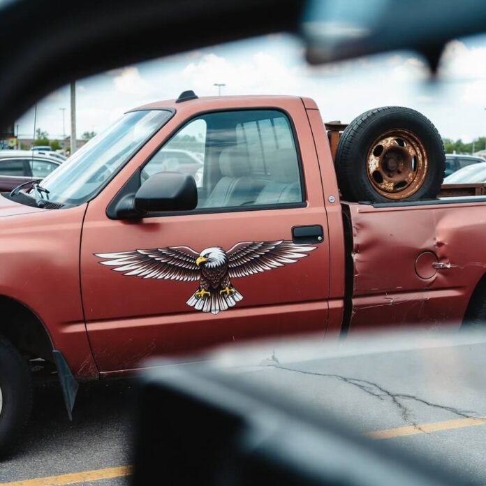 Annoyed parking lot view of rusty truck with eagle statue