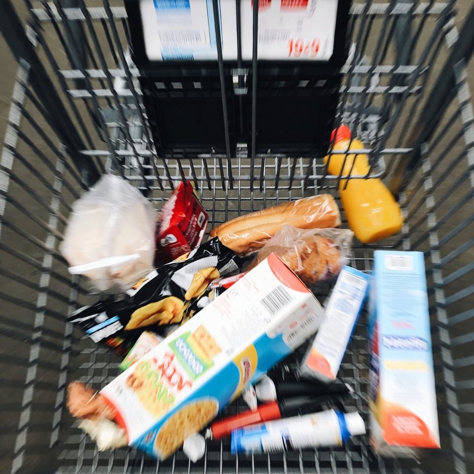 Inside grocery cart view of high-priced everyday items.