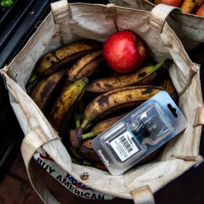 Crumpled grocery tote with bananas, apple, and charger