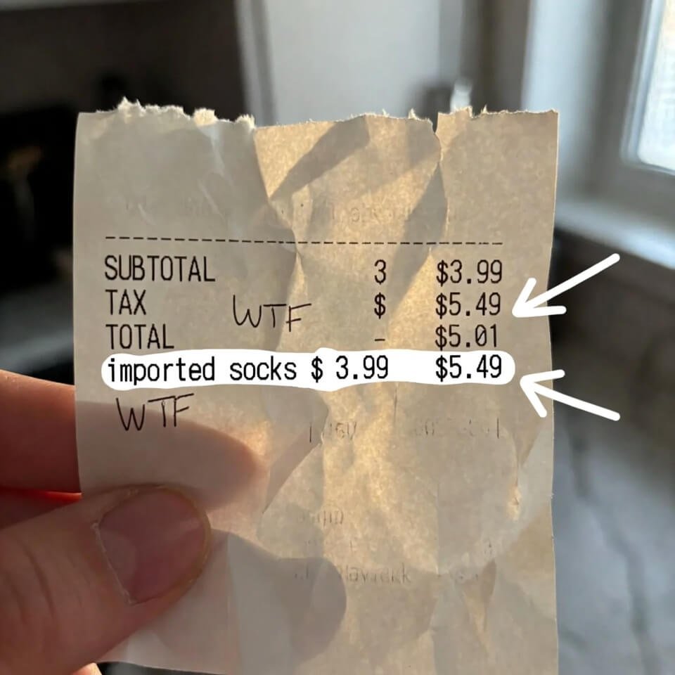 Hand holding crumpled Aldi receipt showing sock price jump