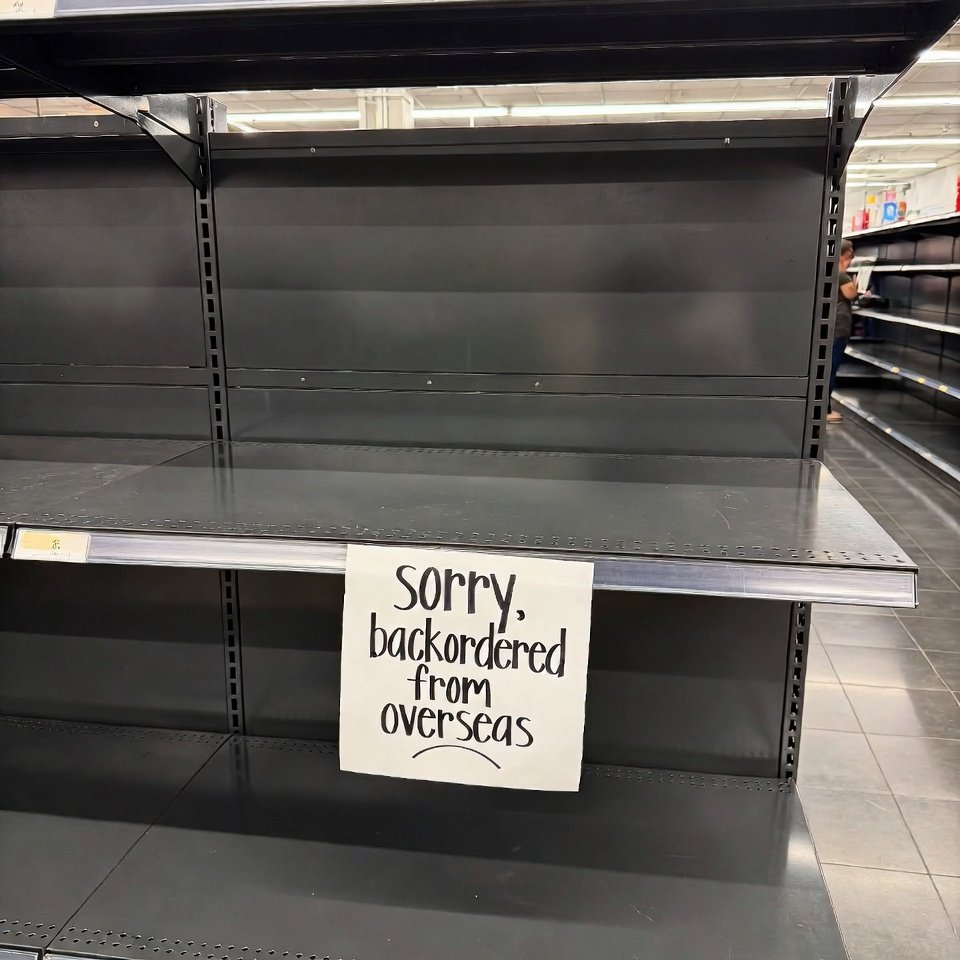 Empty big-box store shelves with "backordered from overseas" sign