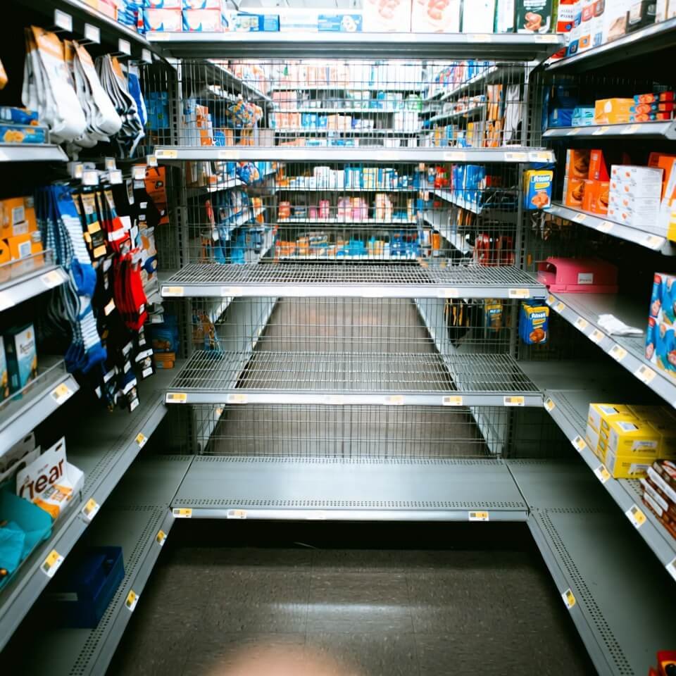 Grainy Walmart aisle from low crouch, half-stocked shelves showing "Made in Vietnam" and "Made in Mexico" labels.