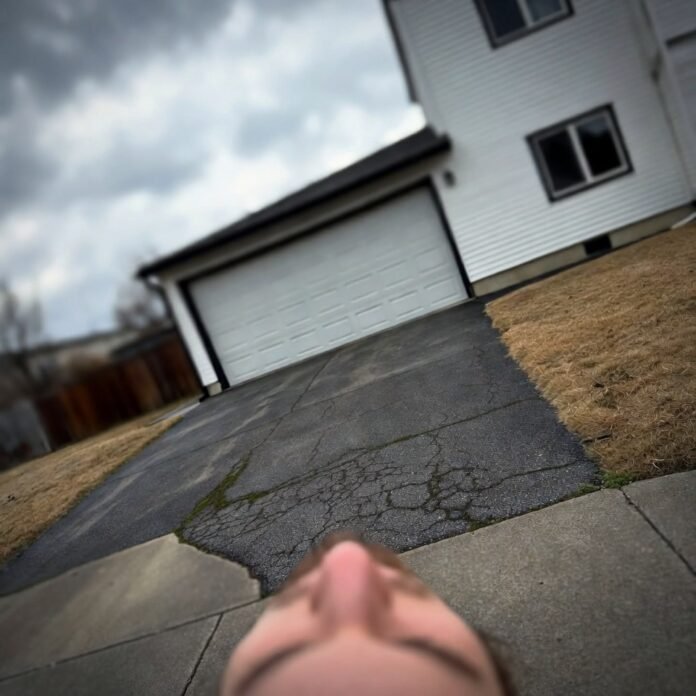 Low-angle shaky driveway shot after work, cracked concrete.