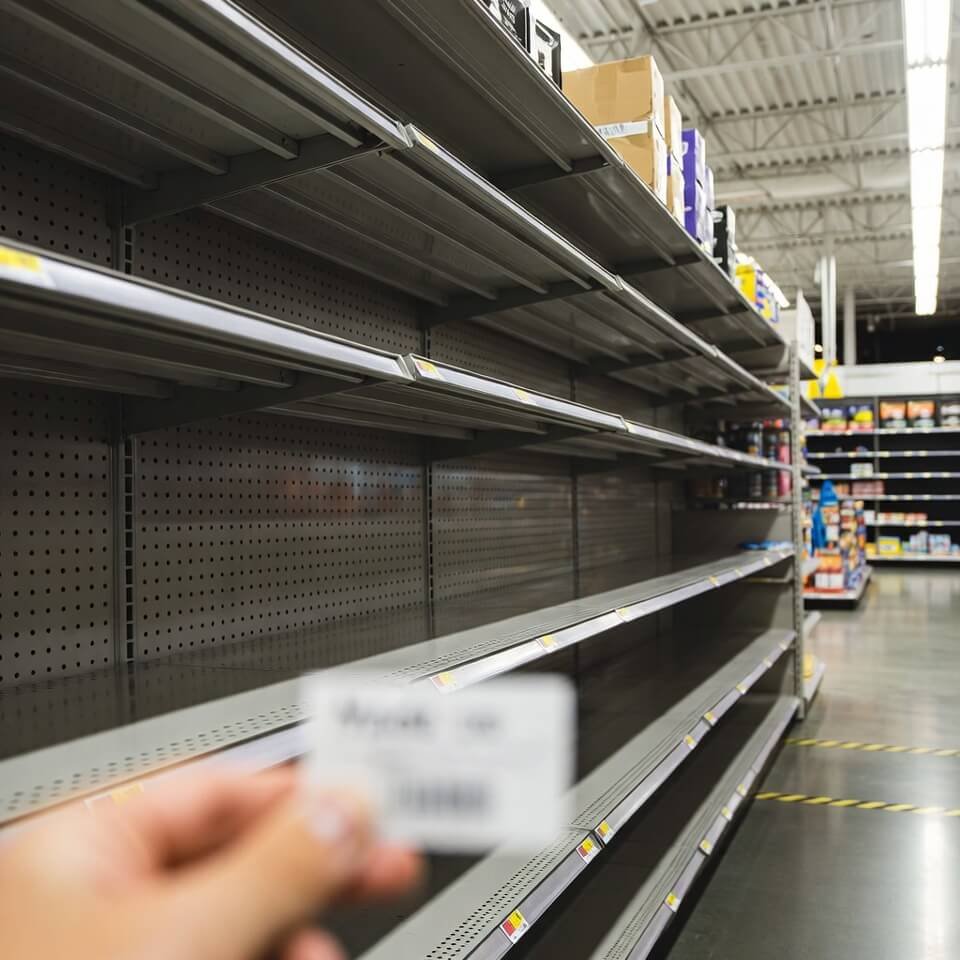 Empty Walmart shelves, hand holding overpriced "Made in USA" label.